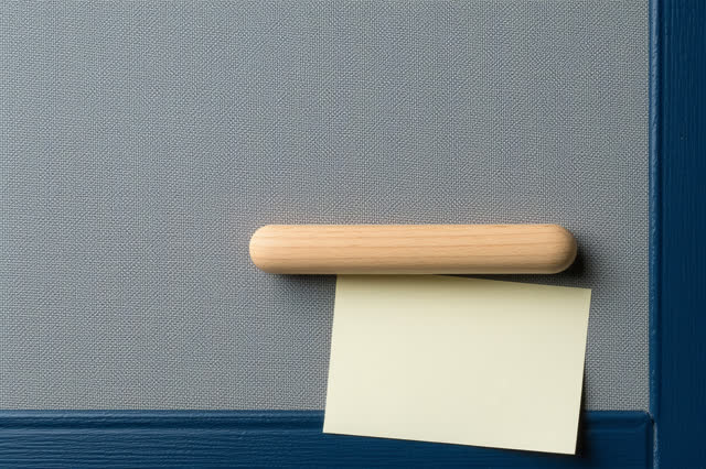 Medium vertical crop in a community-center bulletin hallway after rain; a large faded blue-gray fabric-backed board is b