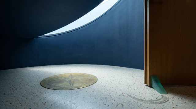 A small planetarium lobby after a school visit, empty of people, with no star charts, maps, readable signage, telescopes