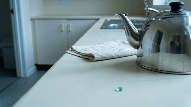A quiet community tea prep room after cleanup, empty of people, with no bath tile reflection, clinic pass-through, garde