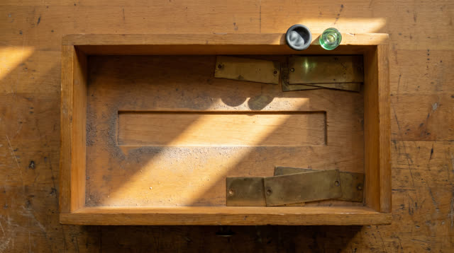A public radio parts drawer pulled open after inventory, empty of people, with no readable labels, question marks, statu