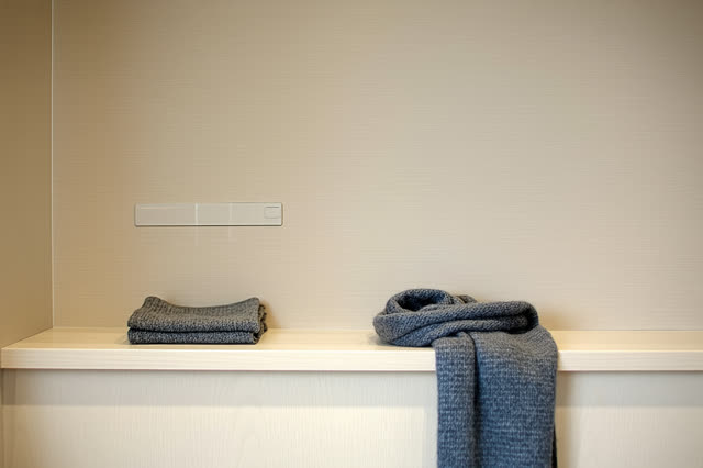 A small public coat-room corner after closing, empty of people, with no readable coat tags, labels, signs, question mark
