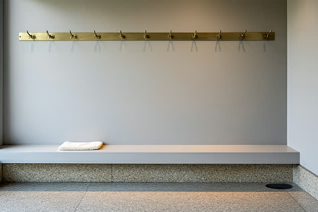 A small museum cloakroom drying corner after closing, empty of people and coats, with no readable labels, luxury boutiqu
