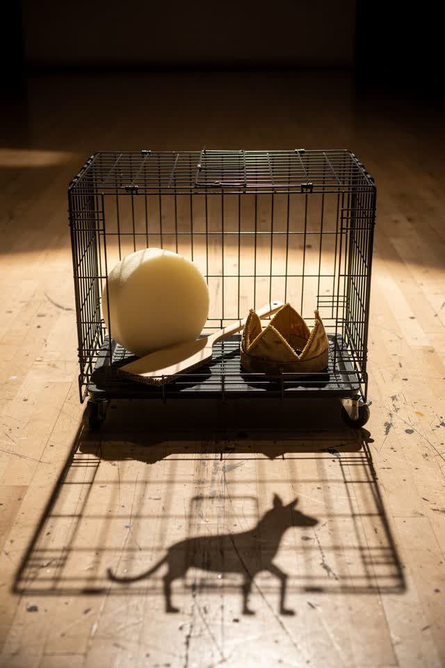 A community theater prop cage after a daytime rehearsal, empty of people, with no readable labels, slapstick faces, larg