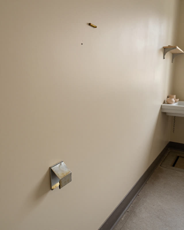 A school kiln room side wall after inspection, empty of people, with no readable labels, ceramics sink chain, clay shelf