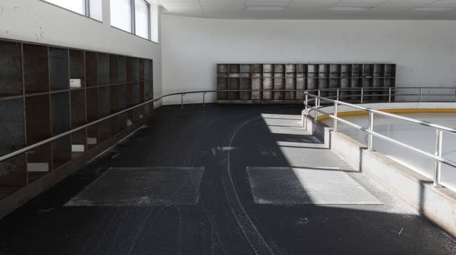 A municipal ice-rink skate-room after public hours, without benches as the main subject and without sports spectacle, em
