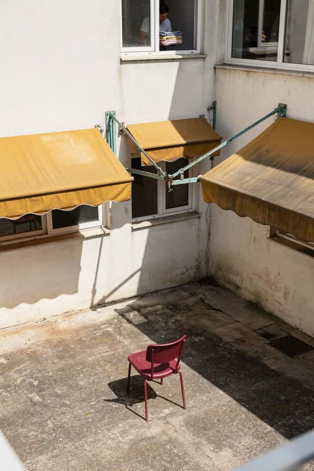 A bright playful image in a dry apartment service courtyard. Three old adjustable window awnings point at visibly differ