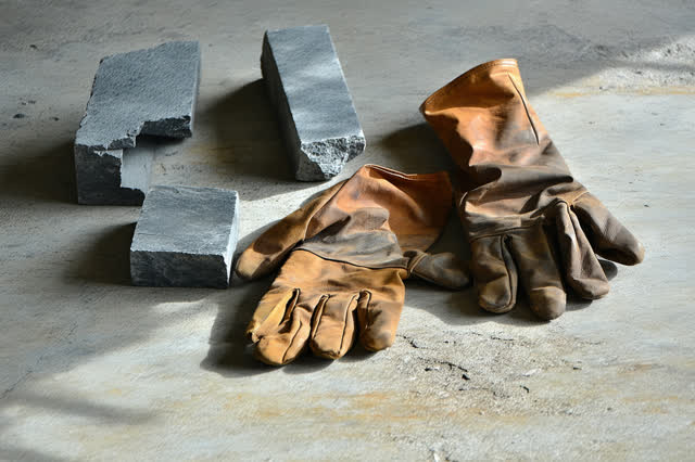 A genuinely quiet industrial still life on a clean concrete floor during a closed lunch hour. Three irregular steel offc