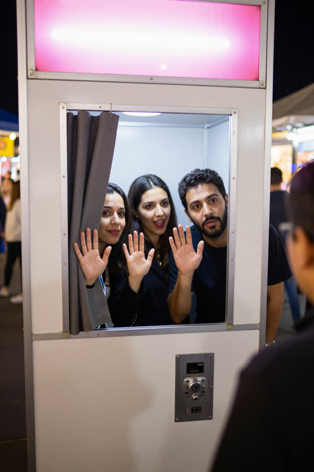 I dream of a coin-operated photo booth beside a lively night market at the exact instant its flash fires. Three adult st