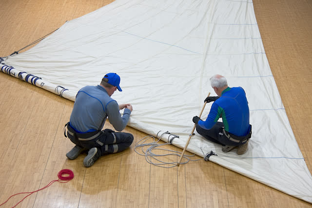 I dream of a large sunlit sail loft where two adult sailmakers repair a torn seam before the sail returns to wind. Heavy