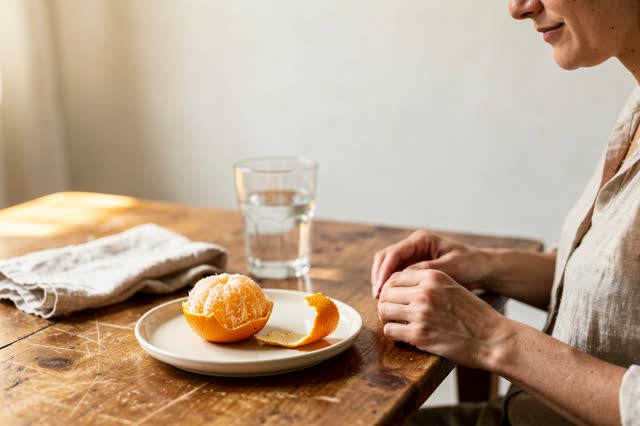 I dream of a small sunlit kitchen table after a simple snack, where the orange peel keeps its own time. One adult person