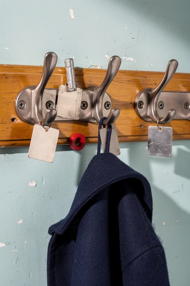 I dream of a bright cloakroom maintenance wall where a short rail of dull nickel coat hooks has quietly organized itself