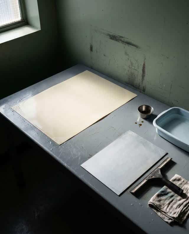 I dream of a quiet stencil-washing table in a public maintenance room. A clean blank stencil aligns perfectly with an ob