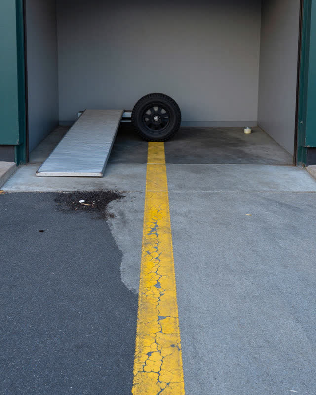 I dream of a covered loading threshold behind a civic supply room where a rolling cart wheel has followed an old chipped