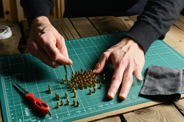 I dream of two natural hands at a small locksmith pinning mat, reseating varied brass pins into a blank cylinder so the