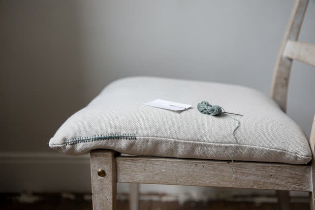 I dream of a quiet reading chair after one small seam has been restitched, calm because the work has disappeared back in