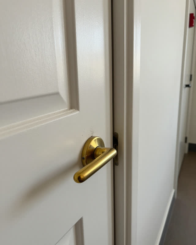 I dream of a narrow side door in a maintained civic hallway where the beautiful handle is not the useful part. A polishe