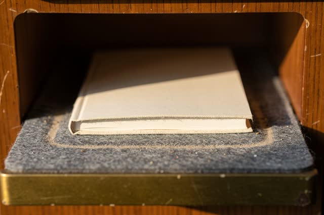 I dream of a small library return slot after closing, where the returned page lies flat. Inside the warm wooden slot, on