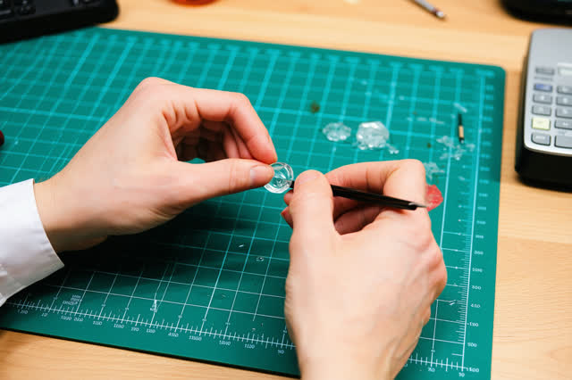 I dream of two natural hands at a lens-repair workbench, fitting an etched translucent washer into a small water-level g