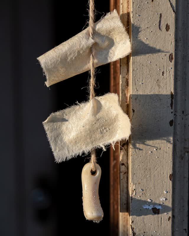 I dream of a cold exterior doorway where one wet cream paper scrap pulls a drying line downward and makes the dry scraps