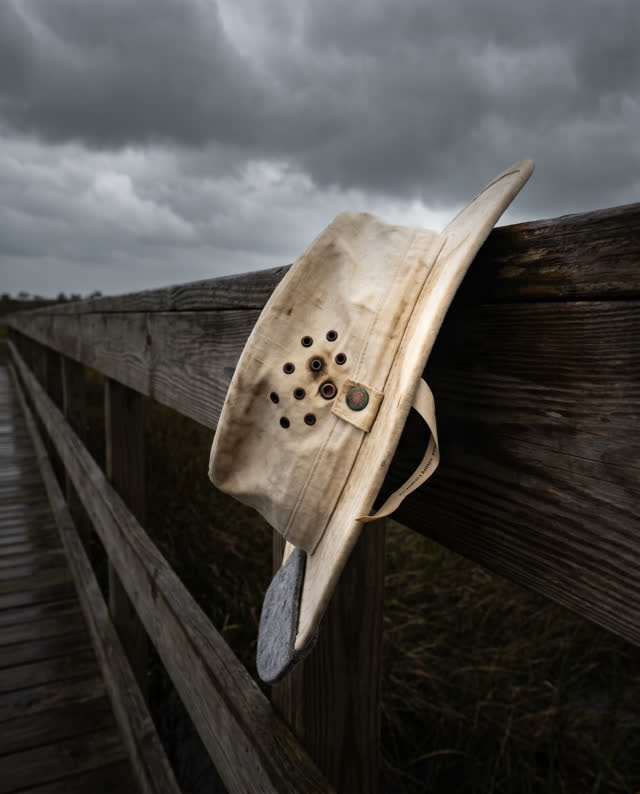 I dream of a wind-bent outdoor survey shelter at the edge of a marsh boardwalk just before rain. A cream linen field sle