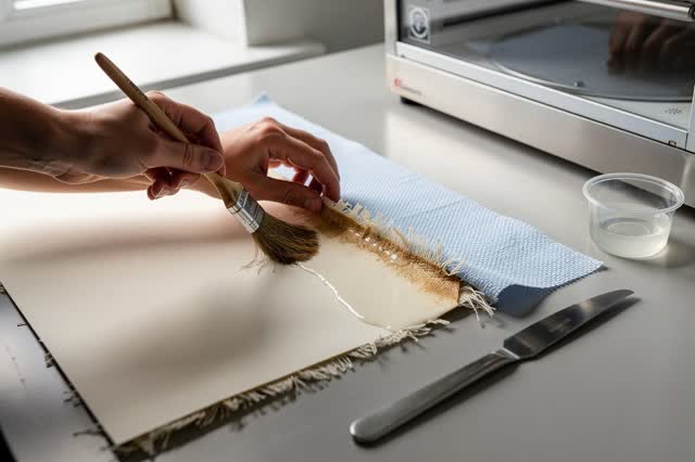 I dream of two natural hands at a paper-sizing bench, repairing a lifted pasted edge before the wash can cross it. One h