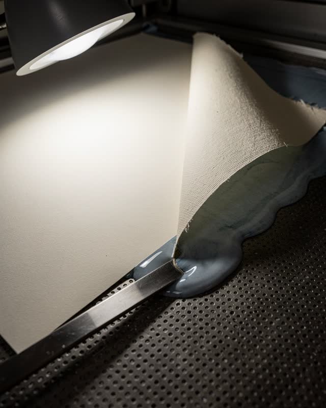 I dream of a tilted conservation vacuum table under a low task lamp. The perforated suction field holds the dry left sid