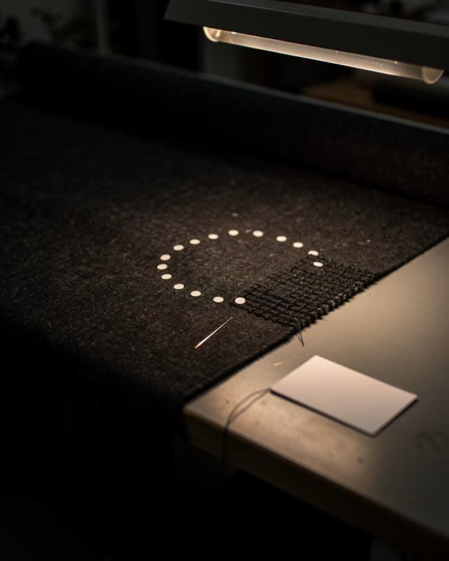 I dream that the work disappears too well. On a dark textile inspection table after the bench lamp has been lowered, a r