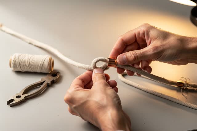 I dream that I give the cord a softer way to bend. At a daylight lamp-repair table, careful hands fit a small strain-rel