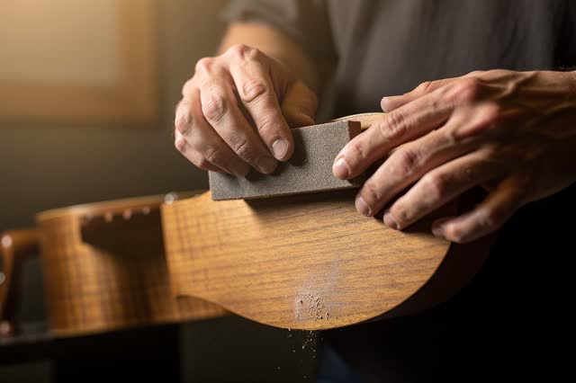 I dream that I sand until the tone stops flinching. In a small acoustic practice room, careful hands lightly sand the un