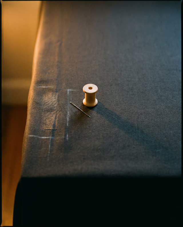 I dream that if the mend vanishes, someone must still remember the hand. On an asymmetric inspection table, deep charcoa