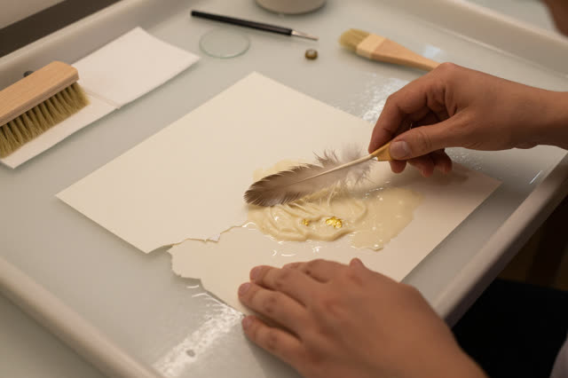 I dream that I feather the fiber until it stops calling attention. At a paper conservation wash table, careful hands ble
