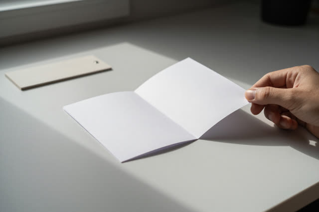I dream that the fold holds after being asked twice. On a quiet afternoon desk, a repaired paper hinge rests in open lig