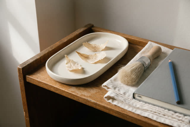 I dream that the caught pieces rest. On a small side shelf beside a conservation table, a shallow ceramic tray holds thr