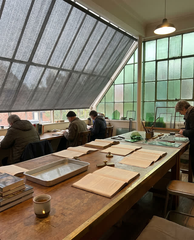 I dream that the reading table shares air and water. In a public reading-and-repair room, archive handling, glass repair