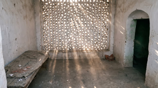 I dream that I watch the wall let light through. In a small public courtyard room with a hand-cut plaster screen, mud-gr